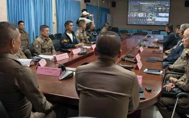 Thai police officers in a meeting room discussing a case.
