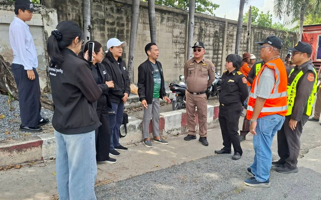 Officials and police inspecting a road area in Samut Prakan.