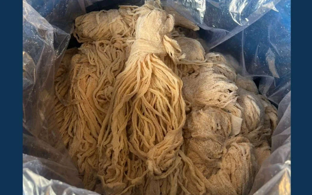 A plastic-lined container filled with pale pork intestines.