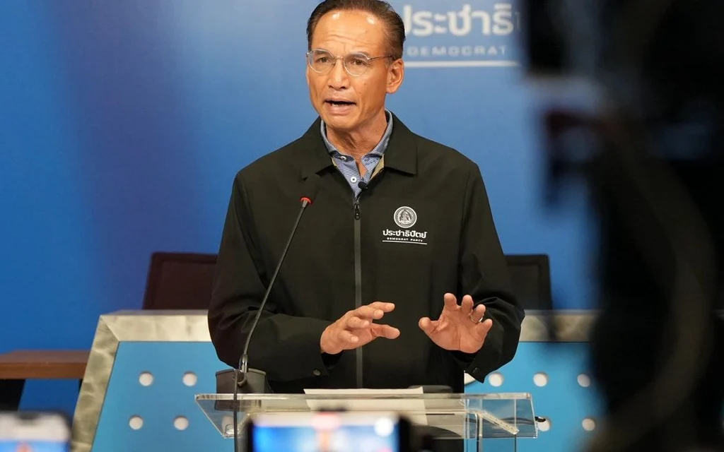 A man speaking at a podium with a blue background.