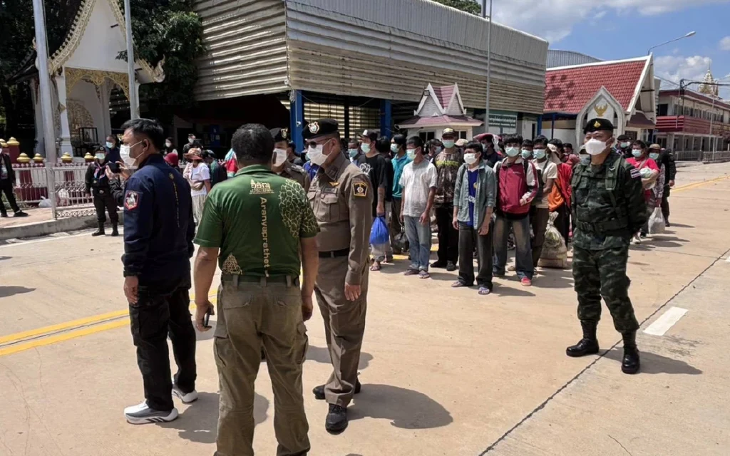 A group of people standing at a border checkpoint