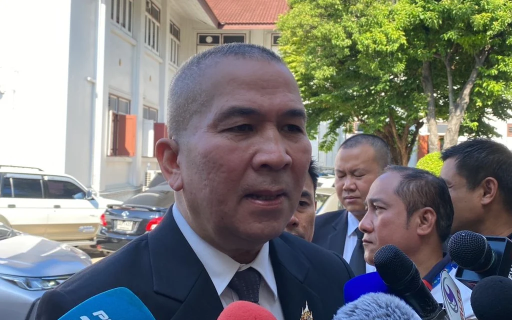 Justice minister speaks to reporters outside a government building.