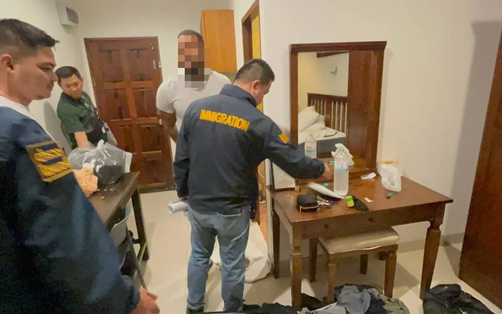 Immigration officers search a room during an arrest investigation.