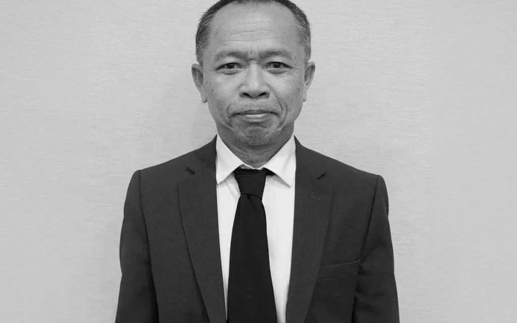 Black-and-white portrait of a man wearing a suit and tie.