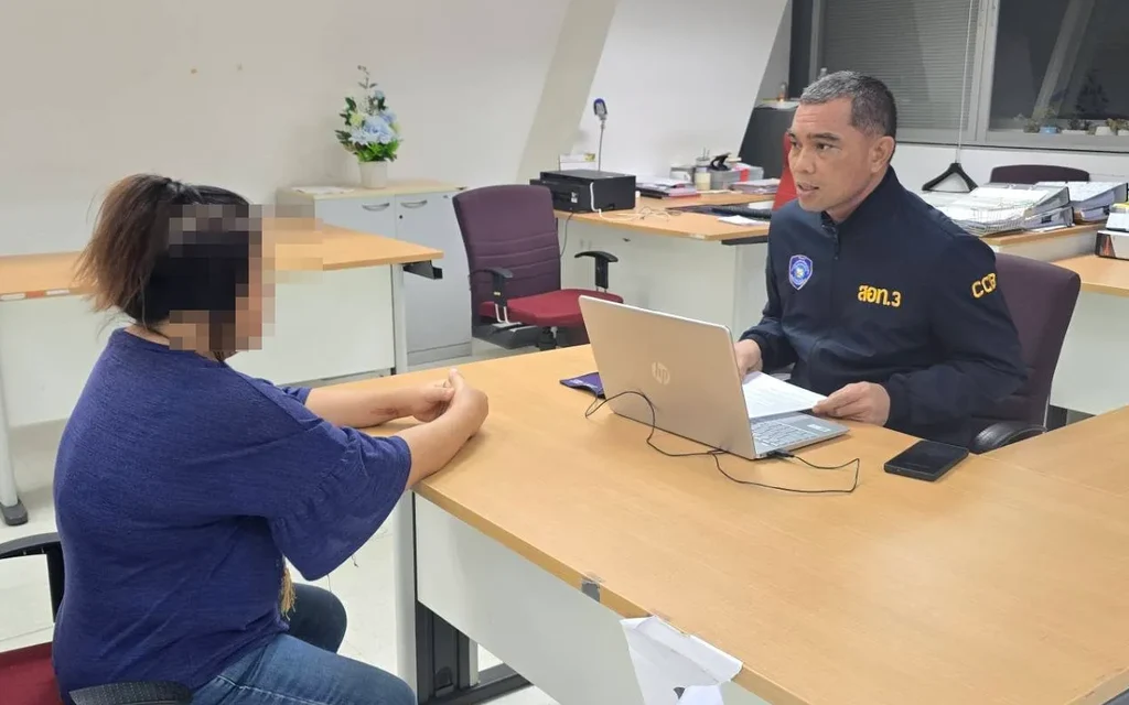 A police officer interviewing a woman in an office setting.