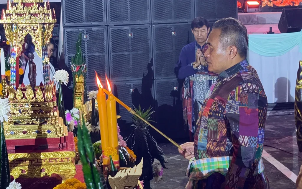 Nong Khai governor performs a ceremony beside an ornate shrine and candles
