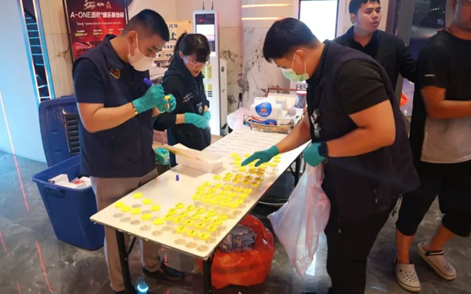Officials inspect documents during a raid at a nightlife venue.