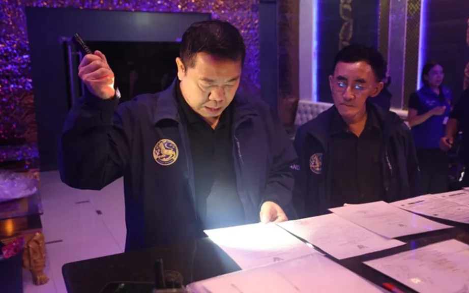 Officials inspect a KTV venue counter during a nighttime raid.
