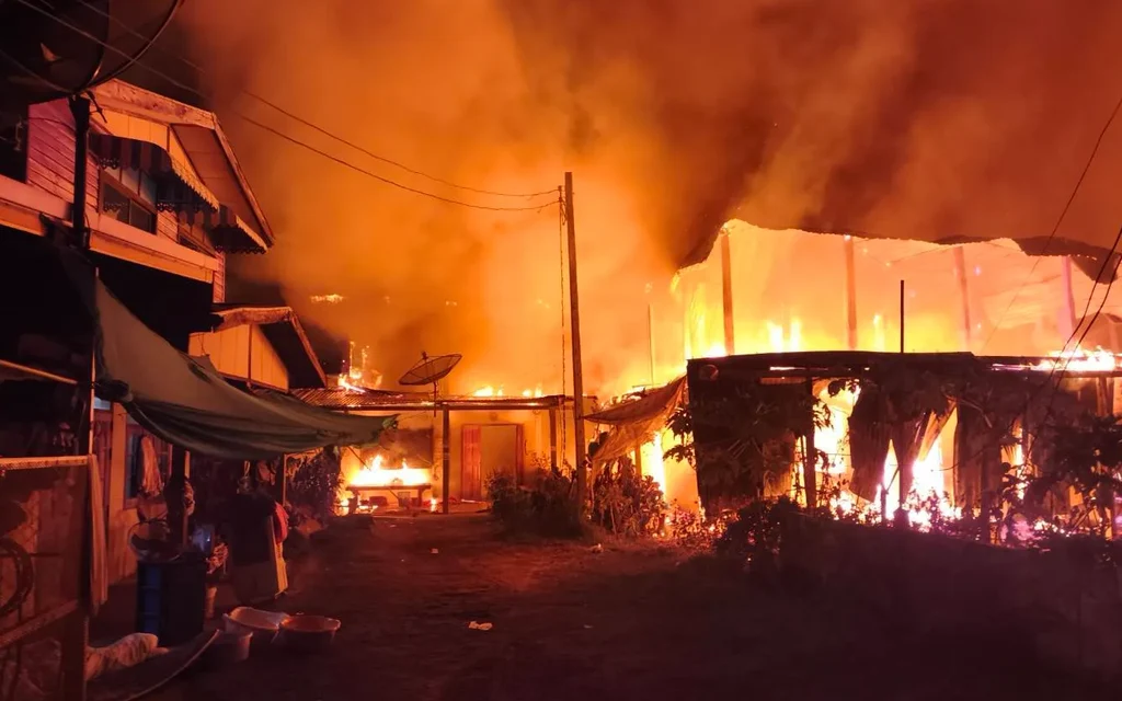 A nighttime fire engulfs houses in a residential community.
