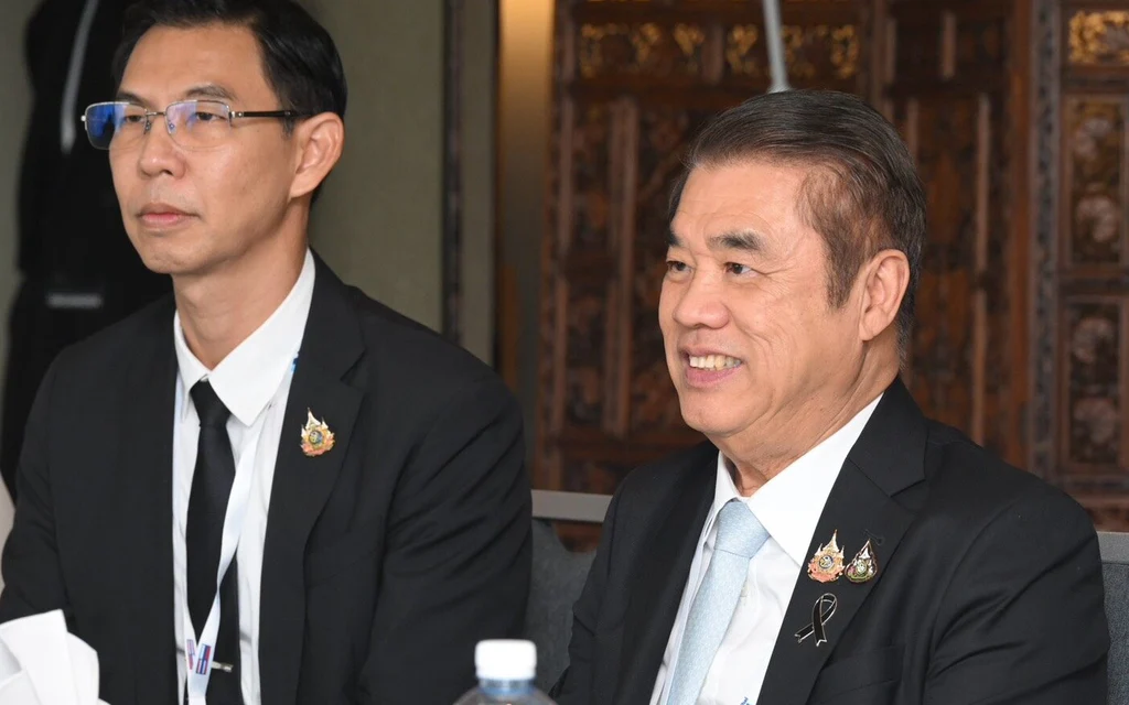 Two men in suits attend a meeting at a table.