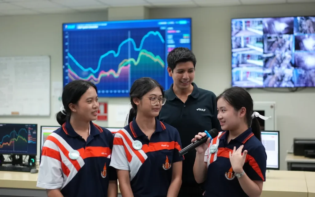 Students participating in a sustainability competition in a control room.