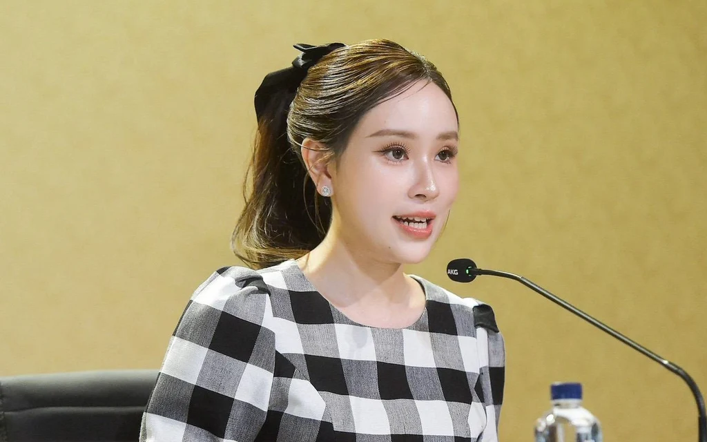 A woman speaking at a press conference or meeting.