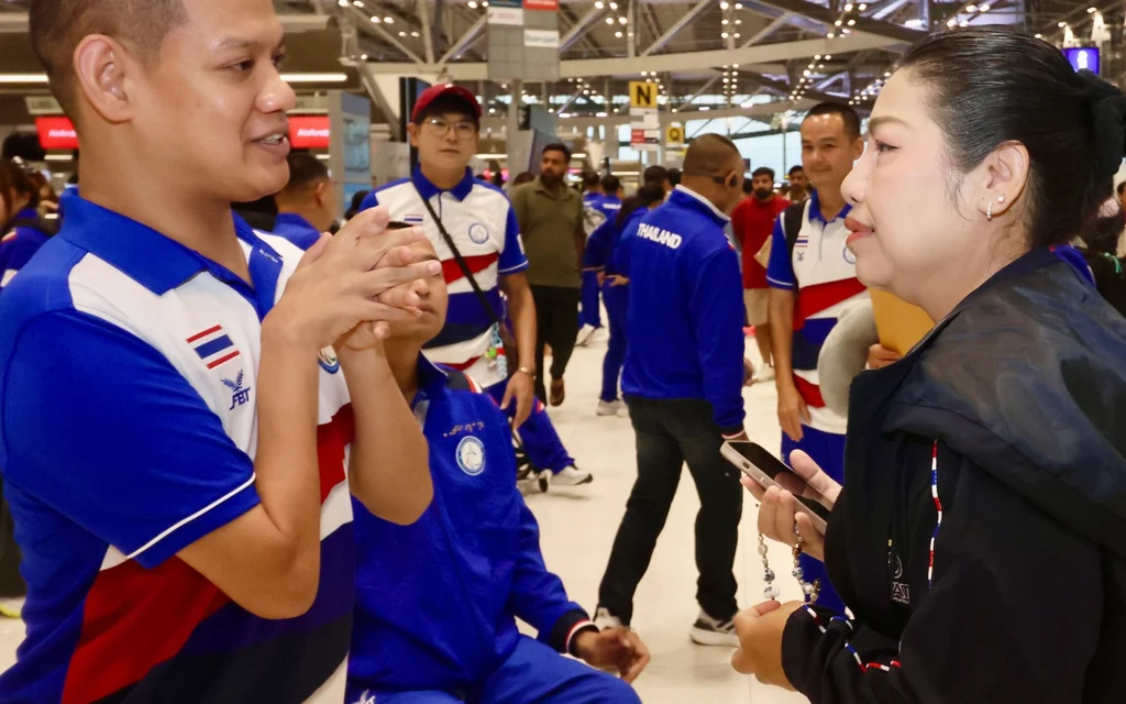Thai para athletes at an airport terminal.