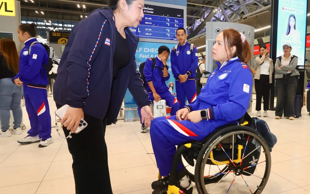 Thai para athletes at an airport terminal preparing for competition.