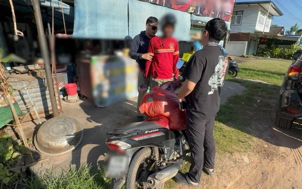 Police officers with a man near a motorcycle.