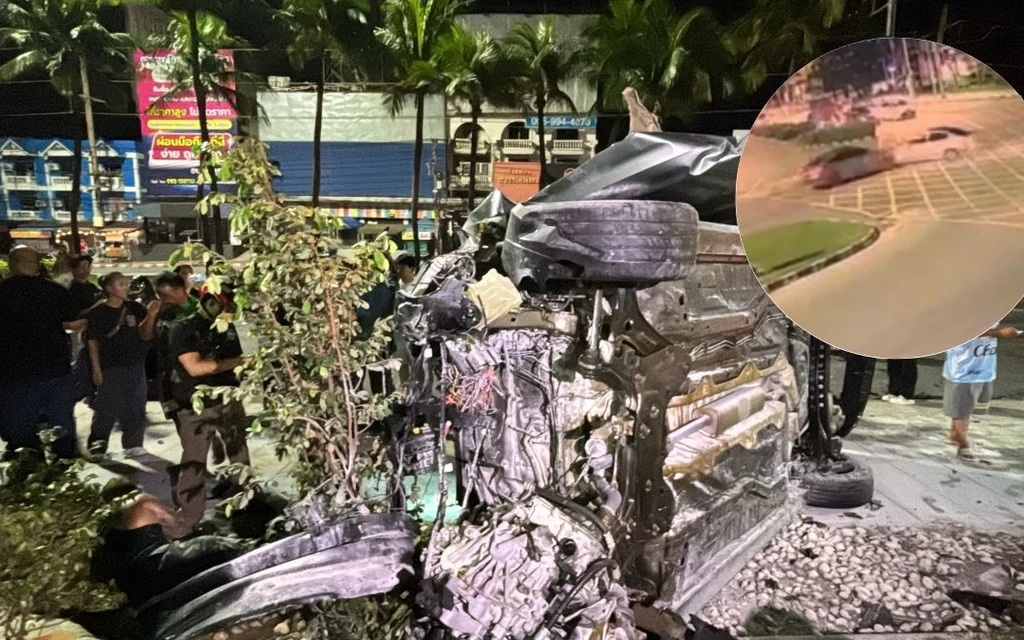 Overturned, damaged car at a nighttime crash scene with bystanders nearby.