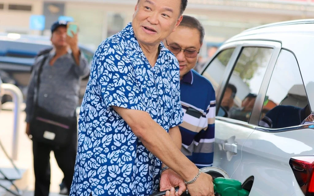 A man fuels a car at a gas station.