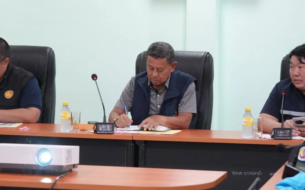 Three men sitting at a table during a meeting.