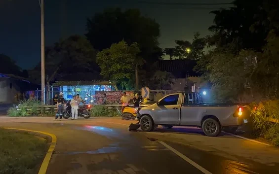 A pickup truck crashed on the side of a road at night.