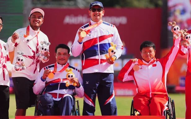Thai para archers celebrate their medals at an awards ceremony.