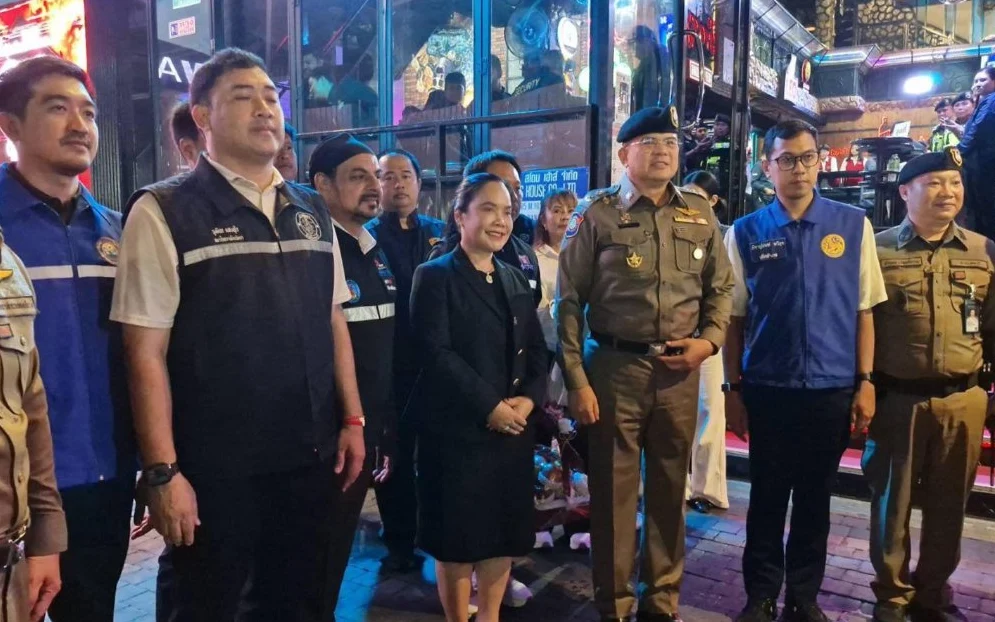 Police and officials pose during a nighttime inspection of entertainment venues.