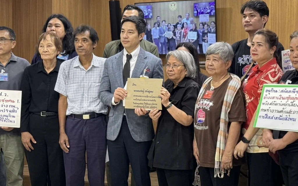 Civil society representatives hold signs and submit a petition at a party office