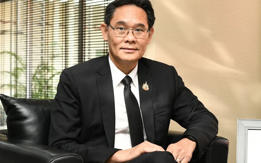 A man in a suit sitting in an office chair.