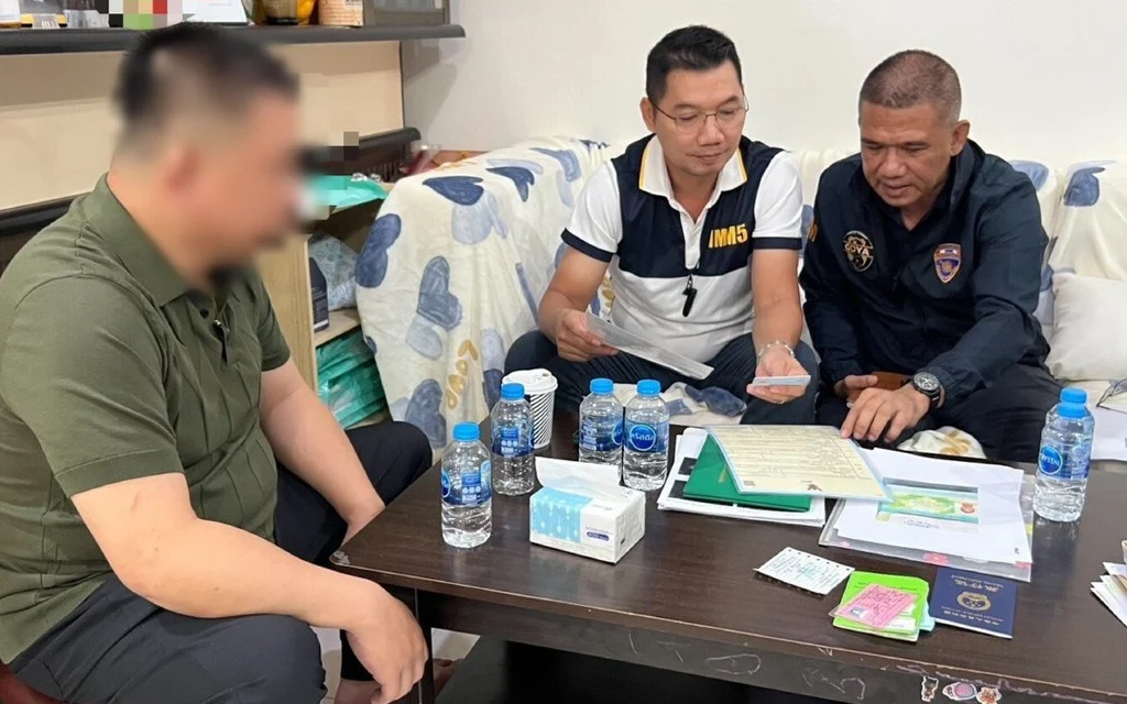 Police officers reviewing documents with a man.