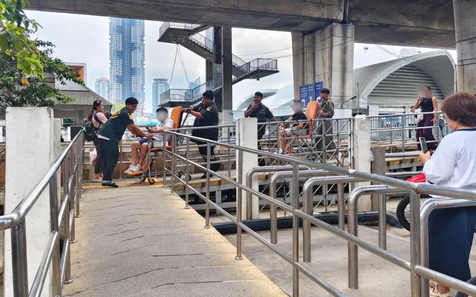People at a pier with railings beneath an elevated structure