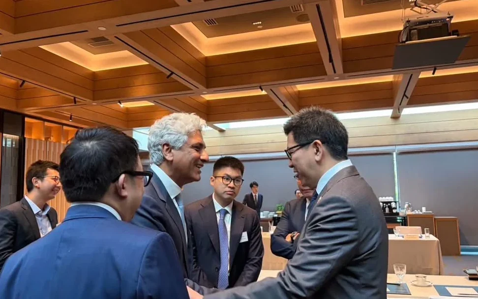 Businesspeople meet and greet in a conference room.