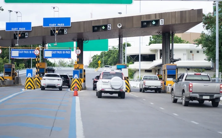 Cars passing through an expressway toll plaza.