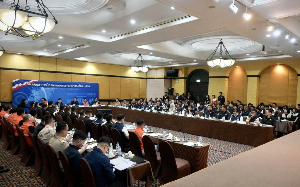 A large group of officials attending a formal meeting in a hall.