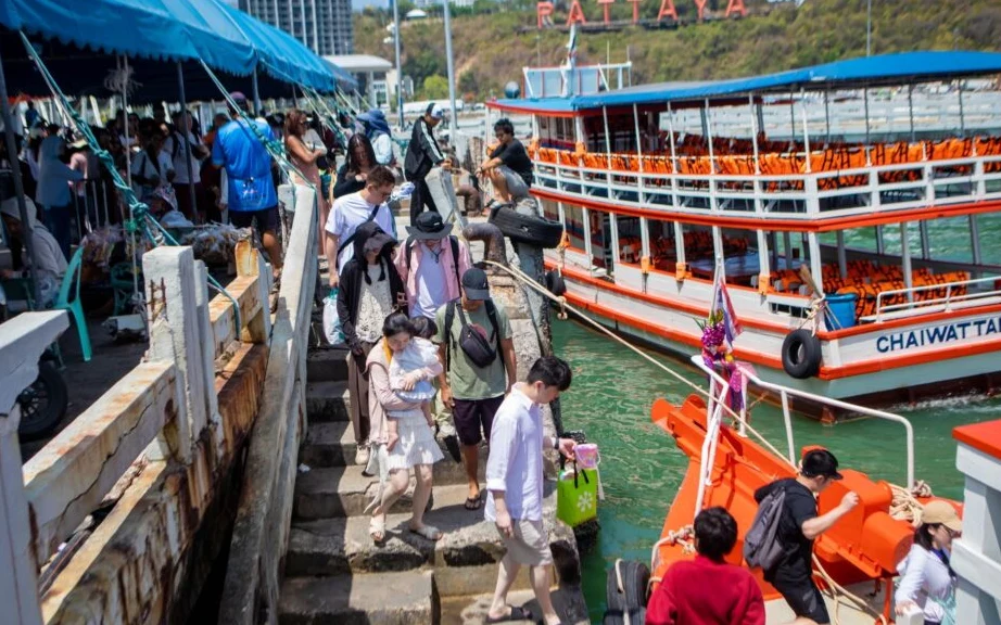 Tourists board ferries at a busy Pattaya pier.