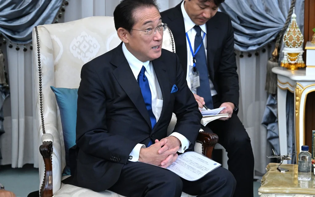 Japanese Prime Minister Fumio Kishida sitting in a chair during a meeting.
