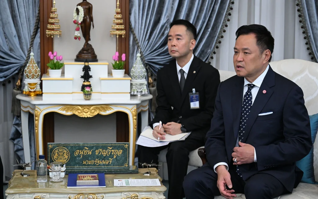 Anutin Charnvirakul sitting in a formal meeting room.