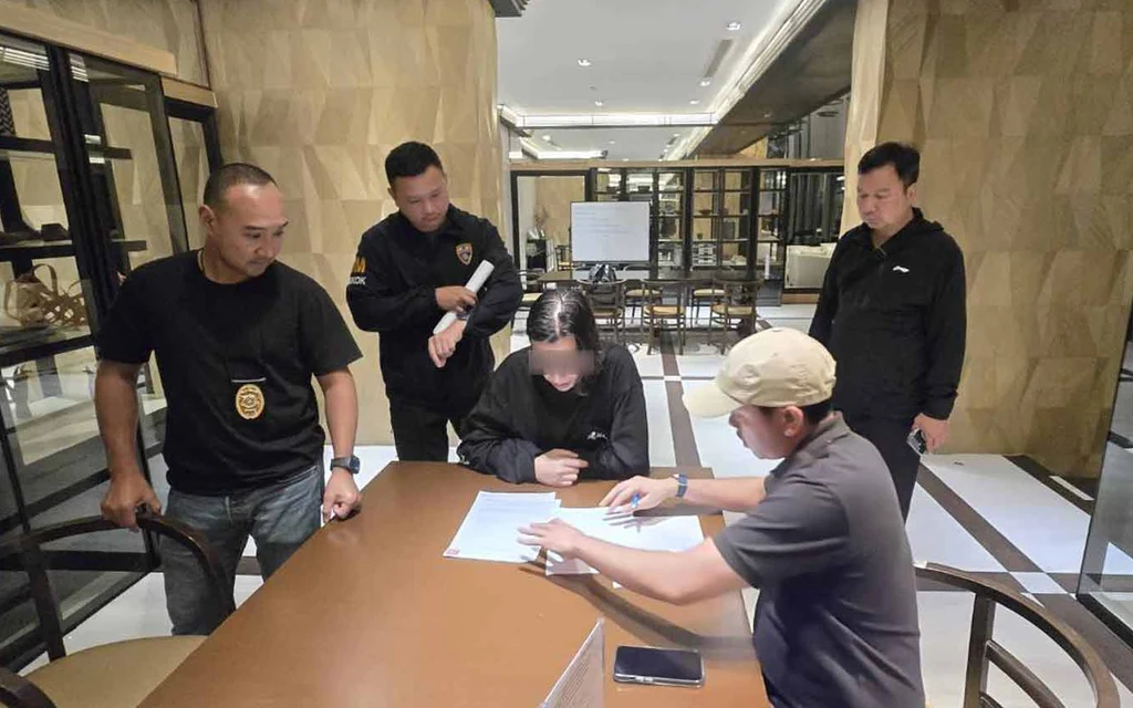 Immigration police questioning a suspect at a table.