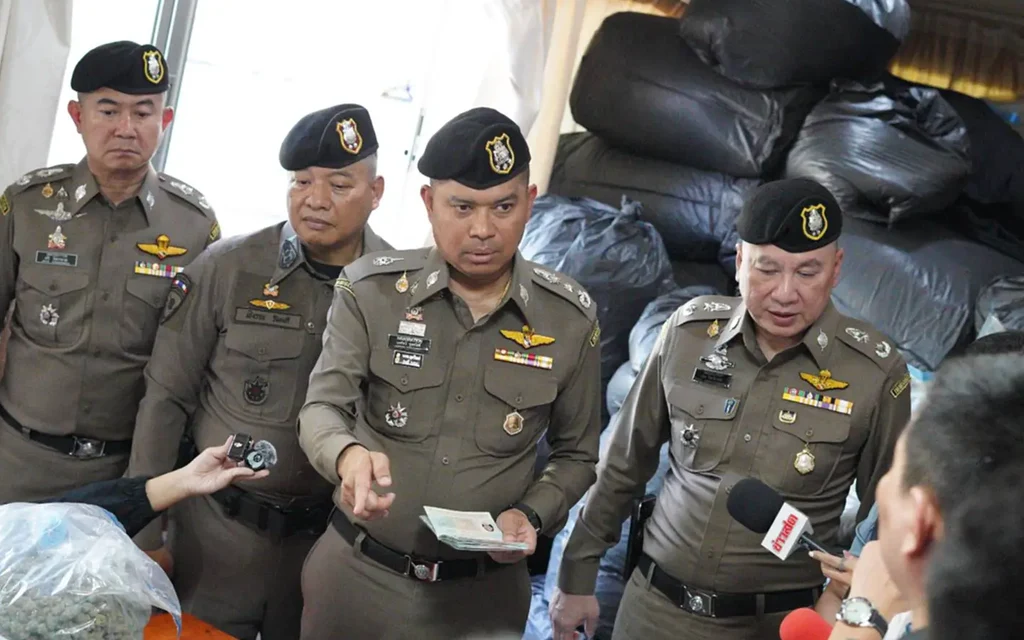Police officers display seized cannabis during a raid.