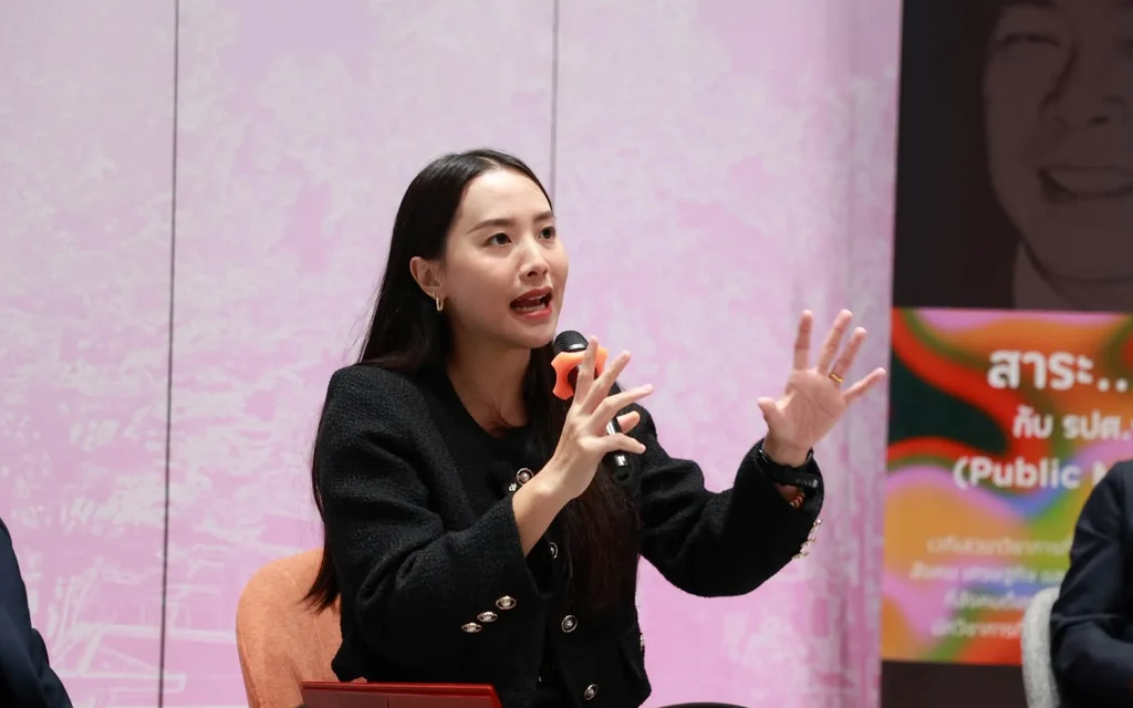 Woman speaks into a microphone during a political panel discussion.