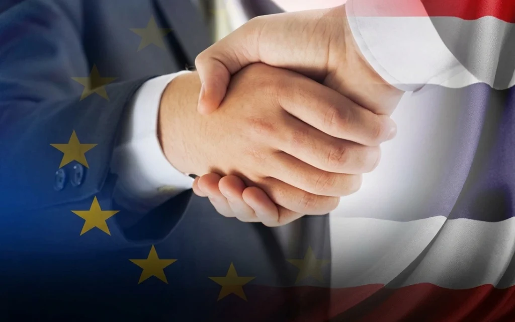 A handshake superimposed over Thai and EU flags.