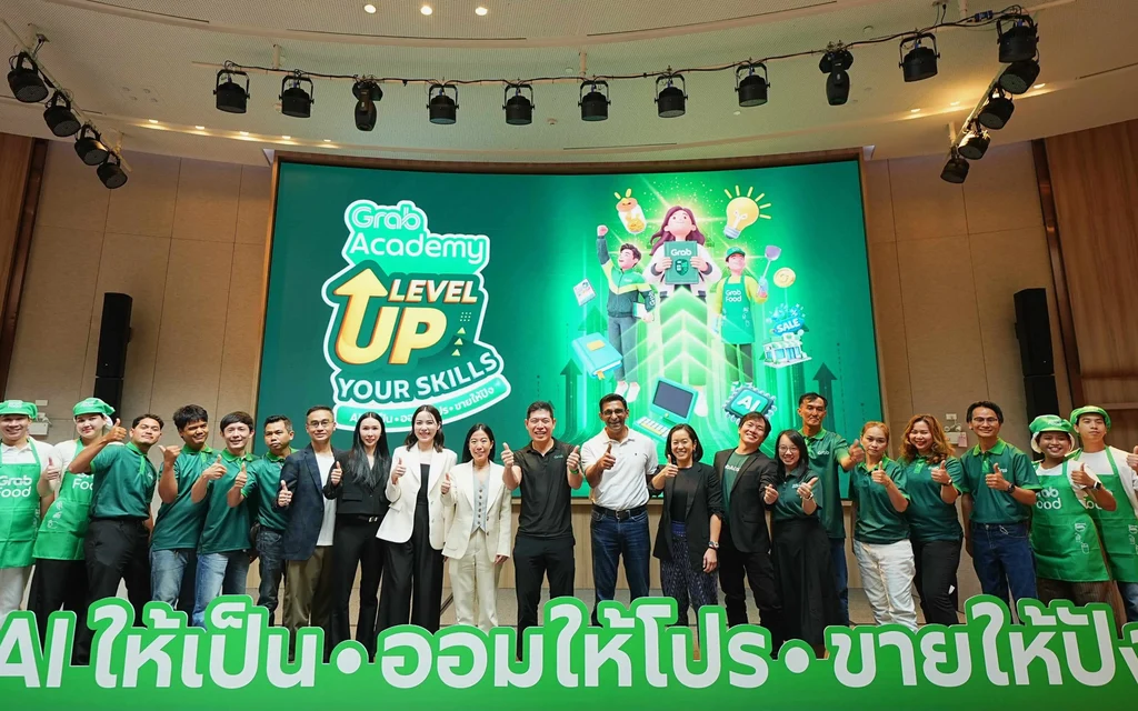 Group of people posing in front of a Grab Academy screen.