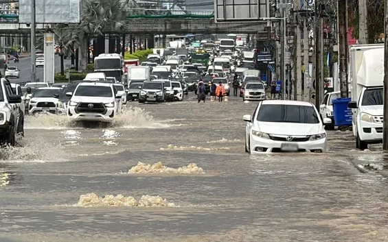 Floodwater covers a busy road as cars drive through Pattaya.