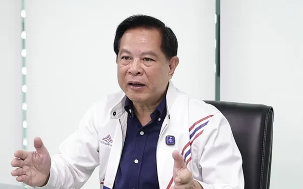 A man in a white jacket sitting at a table.