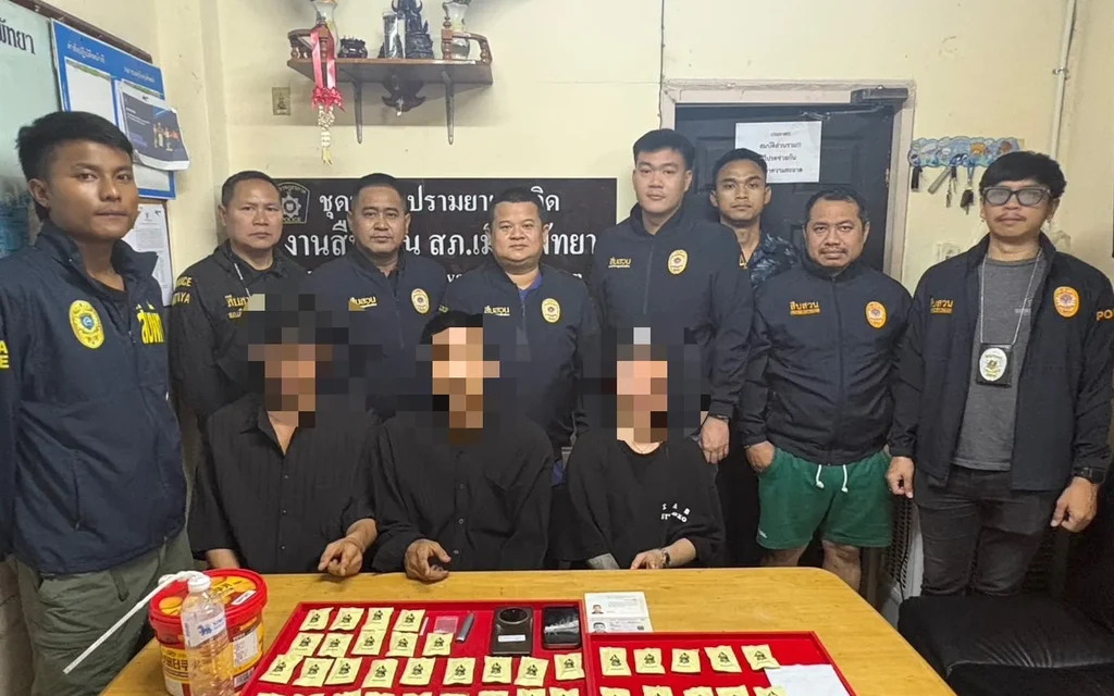Police officers with suspects and seized drug evidence