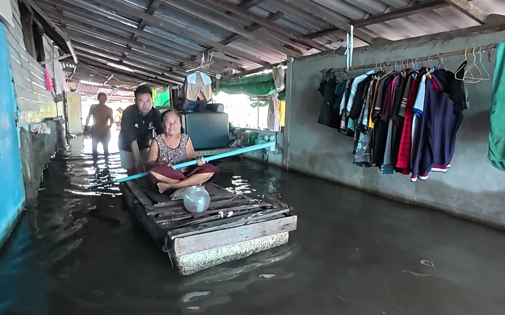 Flood victims sit on a raft inside their inundated home.