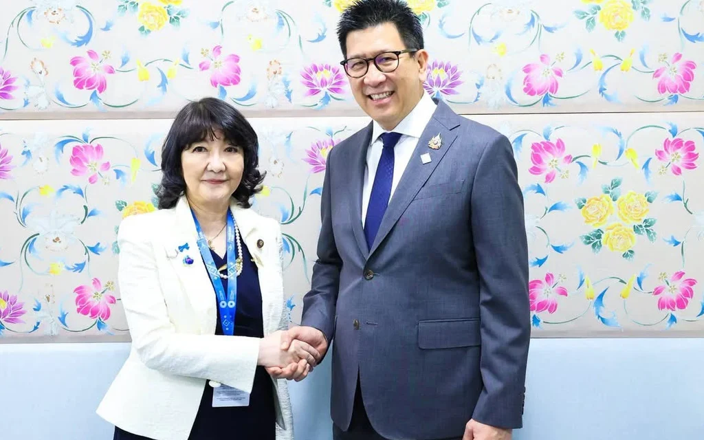 Ekniti Nitithanprapas shaking hands with a Japanese official.