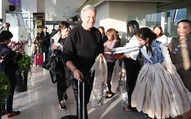 French tourist welcomed by performers and officials at a Thai airport.