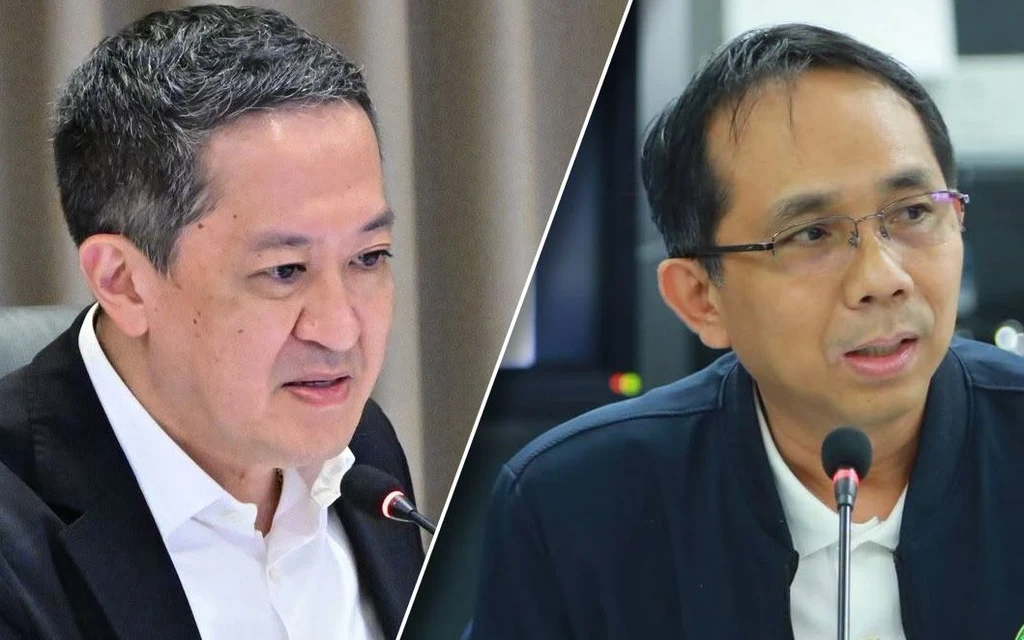 Two Thai government officials speaking at a meeting.