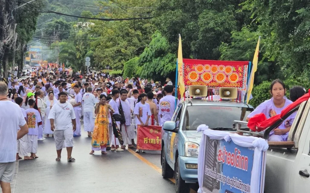 People in white clothes participating in a Phuket Vegetarian Festival procession.