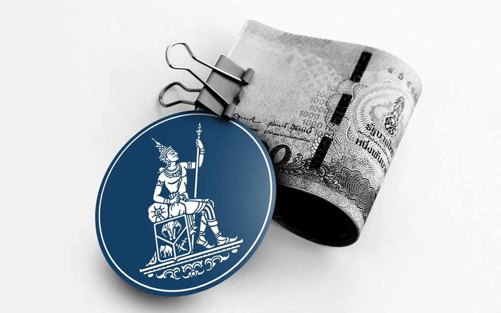 Thai banknote clipped to a blue emblem medallion