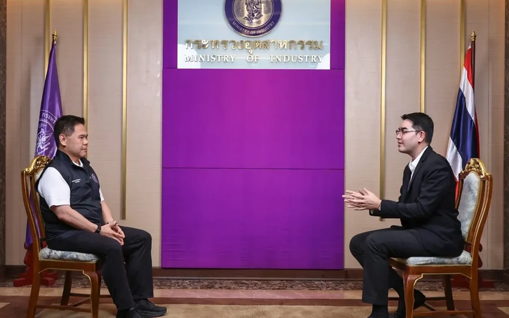 Two men converse in a Ministry of Industry office.